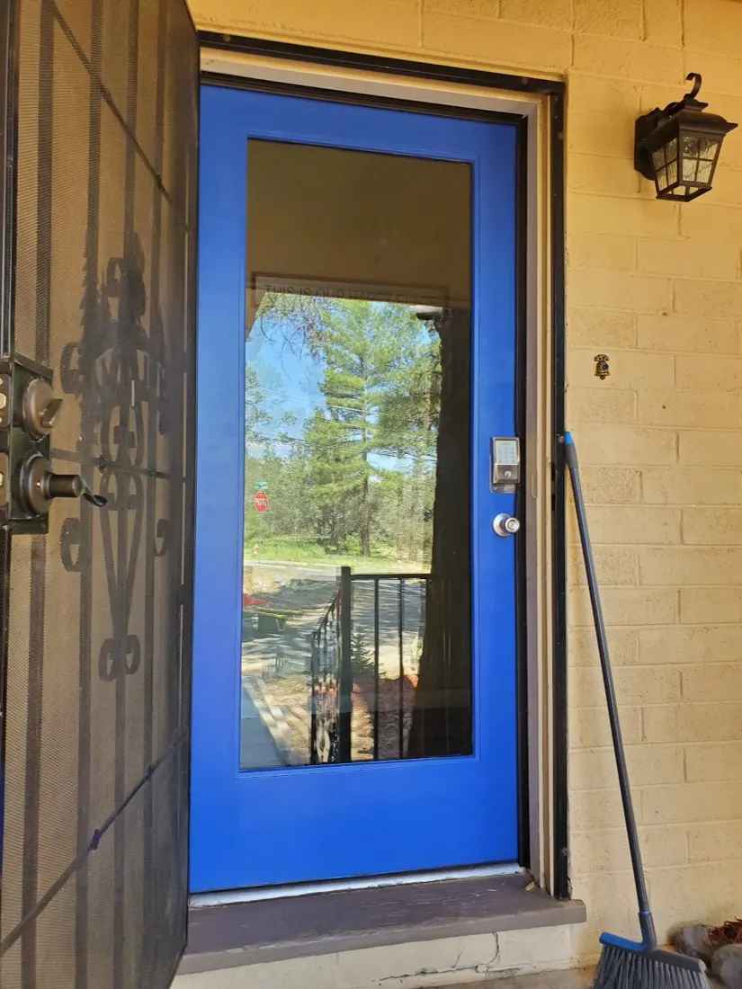 Blue full-glass front door with a keypad deadbolt and security screen door