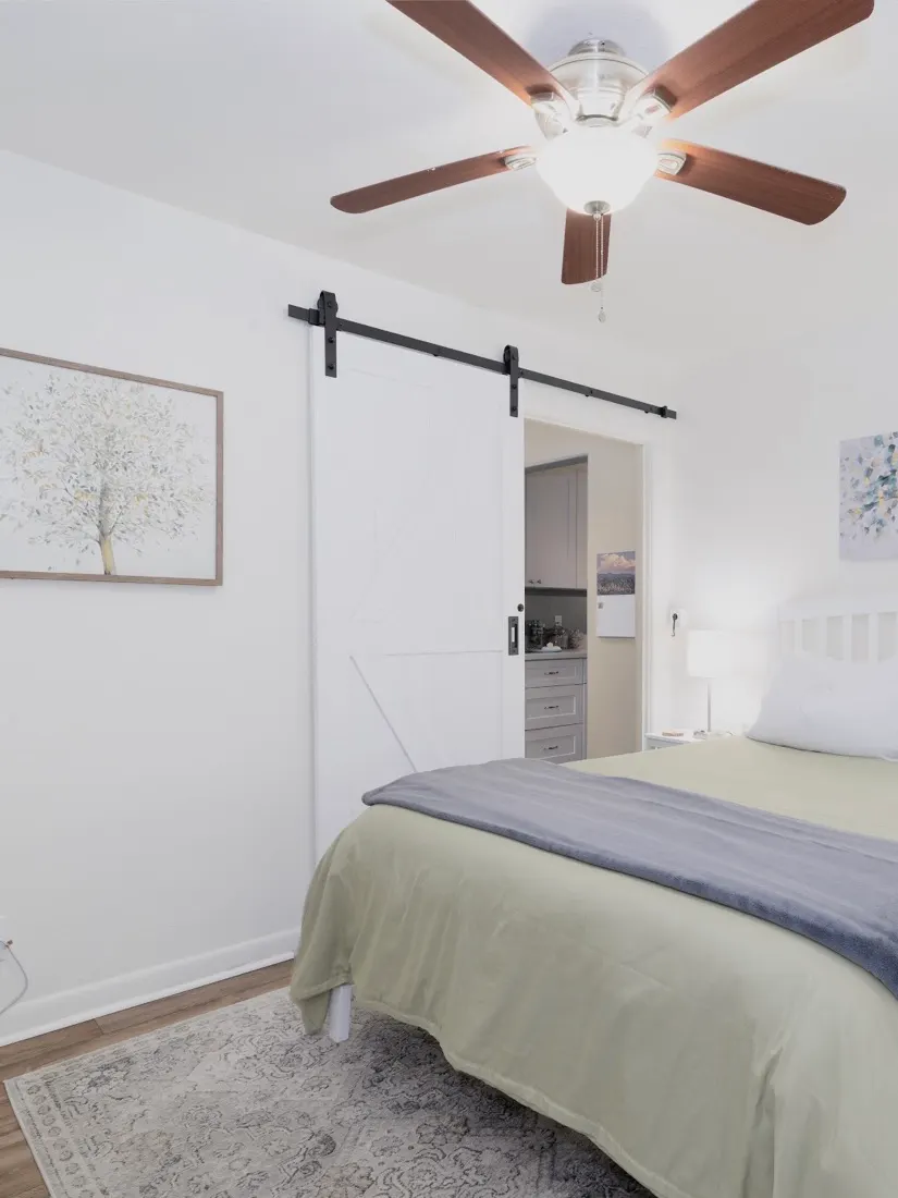 White sliding barn door on black hardware in a bedroom