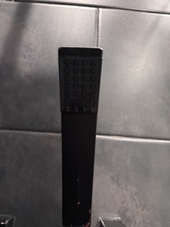 Calcium buildup removed from a black handheld shower head