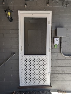 Screen door with a lattice kick panel on a back entry
