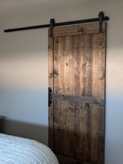 Stained wood sliding barn door in a bedroom