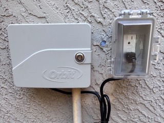 Weatherproof outdoor outlet powering an irrigation controller