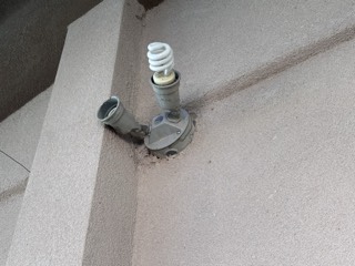 Broken exterior flood light fixture found on a home check