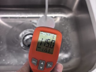Checking hot water temperature at the kitchen tap