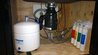 RO system with storage tank and filters installed under a kitchen sink