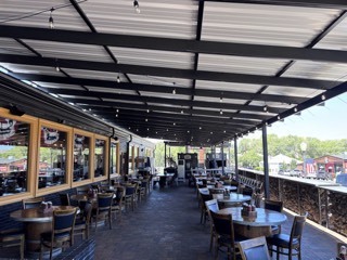 Commercial bistro light install across a covered restaurant patio