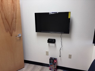 Wall-mounted TV with a console shelf in an office