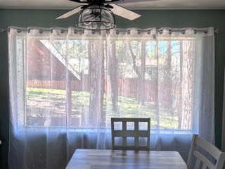 Embroidered white sheer curtains on a wide dining room window