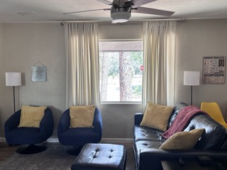 Cream pleated curtains on a brushed nickel rod in a living room
