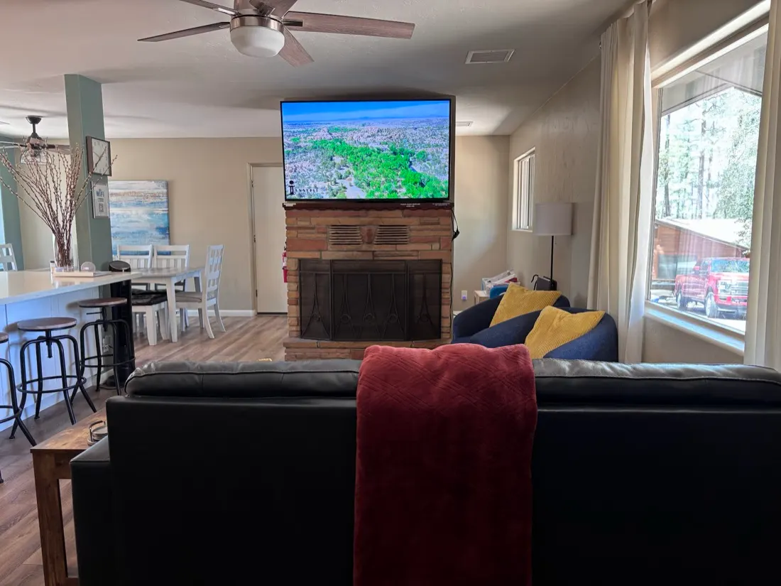 TV mounted above a stone fireplace in a mountain cabin